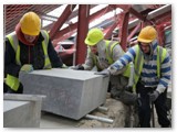 15 Michael Cregg, Gary Cregg and Christopher Donnegan move the coping stone into place on top of fresh mortar