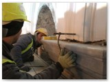 19 Workers make sure that the top of a side wall pilaster is level