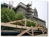 16 The truss is lifted off the lorry by the tower crane