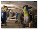 21 A team of plasterers working on finished ceiling follow close behind