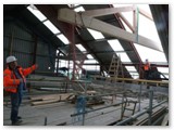 27 Great skill, patience and co-operation is needed between the tower crane operator and the men just inside the tempory roof