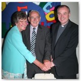 32 Fr Tom cuts the cake with his parents May and Rutledge